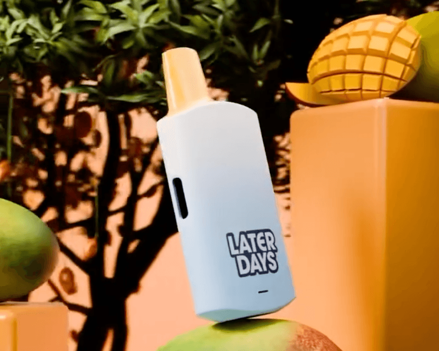 Later Days mango flavor disposable vape with sliced mango on an orange backdrop in NJ